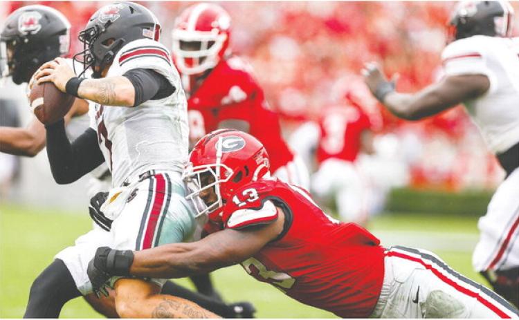 Georgia sophomore edge rusher Mykel Williams (13) brings down South Carolina quarterback Spencer Rattler. TONY WALSH/UGA Athletics