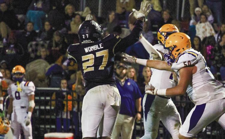 JMA senior Isaiah Womble makes a play on Tatnall Square quarterback Caden Faulk last Friday in Milledgeville. TREY NORRIS/Staff