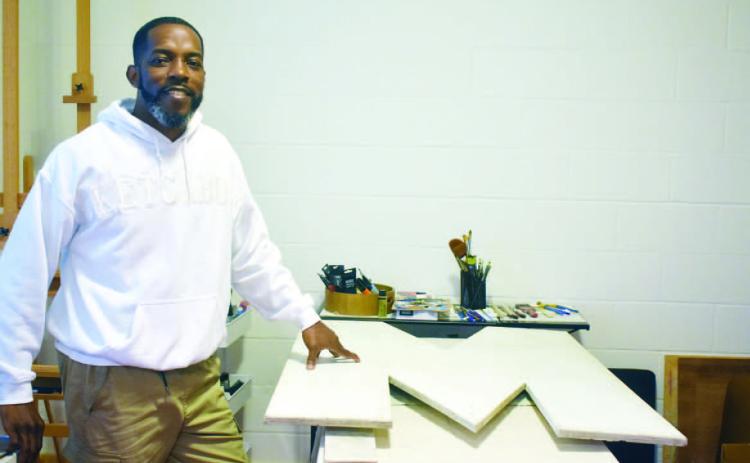 Reginald Stanley – owner of Sketchbook Studio – works on the letter M of MILLY. BAILEY BALLARD/STAFF