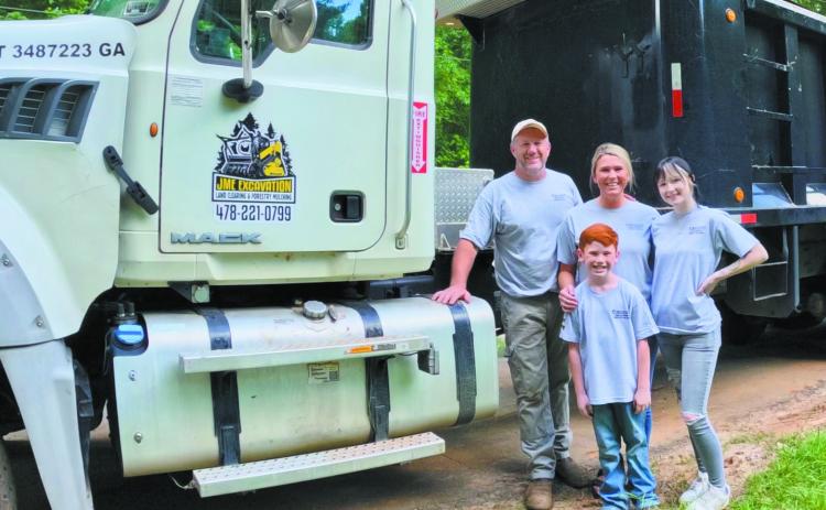 John McIntosh with his family in front of one of their trucks and other equipment used for JME Excavation. CONTRIBUTED BY JESSICA MCINTOSH