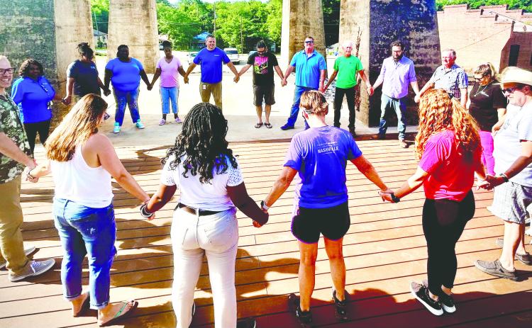 The Life Enrichment prays with Georgia Power and Body Plex employees, community volunteers, New City Church at the Mill members, and Morning Grind owners on the new deck in preparation of opening the Urban Arts Village, July 15.