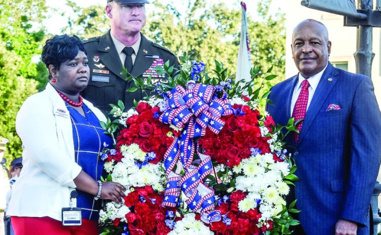GMC President Major General Terrence McKenrick (back), Sergeant Major Al McMichael (right), and Gold Star widow and GMC Prep Elementary School Para Pro Shanoca French laid a wreath at the flagpole in honor of the many lives lost during 9/11. BAILEY BALLARD/Staff