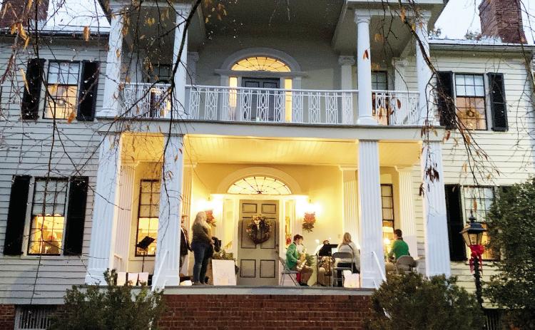 The Baldwin High School sax ensemble performed on the front porch of the historic home welcoming people in. Two attendees stopped to watch and hum along to the tunes of Christmas songs. BAILEY MCCULLY/Staff