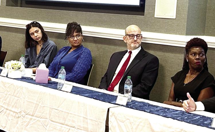 Candidates Mary Parham-Copelan, Walter Reynolds, Morgan Pendergass, Arlene Simmons, Brooks Snyder, and Shidonna Solomon listen as Jeffery Wells speaks. ALIVIA BLANTON/Staff
