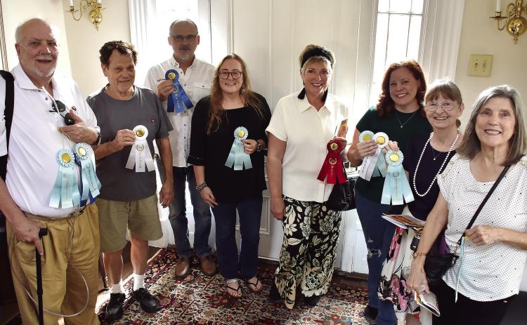 The winners and honorable mentions, excluding Big Click second place winner Allyn Rippin, of the Oconee Artists Exhibit and the Big Click: Beyond the Lens Exhibit gathered to show off their ribbons to attendees of the reception in the Marlor House in downtown Milledgeville. BAILEY BALLARD/Staff