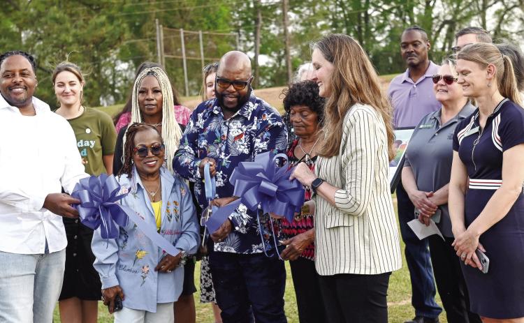Author Steve J. Zachary and other community members cut the ribbon to the new Tale Trail in the Harrisburg Community.