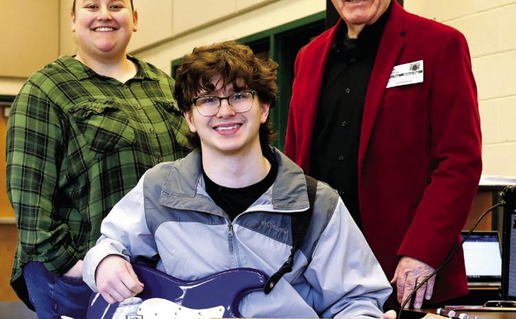 Baldwin High School music teacher Robyn Meeks, Milledgeville First Methodist Church music minister John Cotton, and Baldwin High School student Kyle Camilla pose for the Putnam Christian Outreach Angel Tree presentation of a Fender Squire Stratocaster electric guitar. CONTRIBUTED