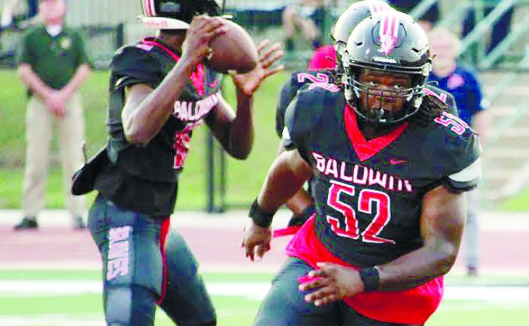 Braves’ quarterback Lamar Pounds stands tall in the pocket as sophomore offensive guard Jaylen Sherman (52) blocks for him. 