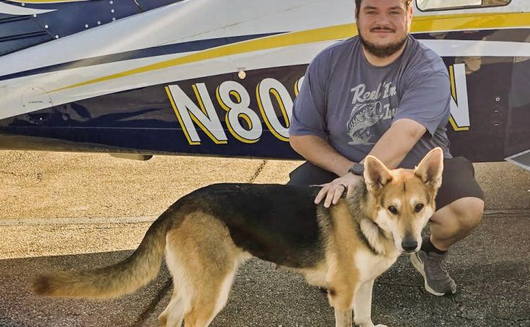 Mila, a three-year-old deaf German Shepherd, stands with pilot Spencer Titzmann, with Pilot and Paws, before taking flight from the Baldwin County Regional Airport heading to Maryland. | CONTRIBUTED