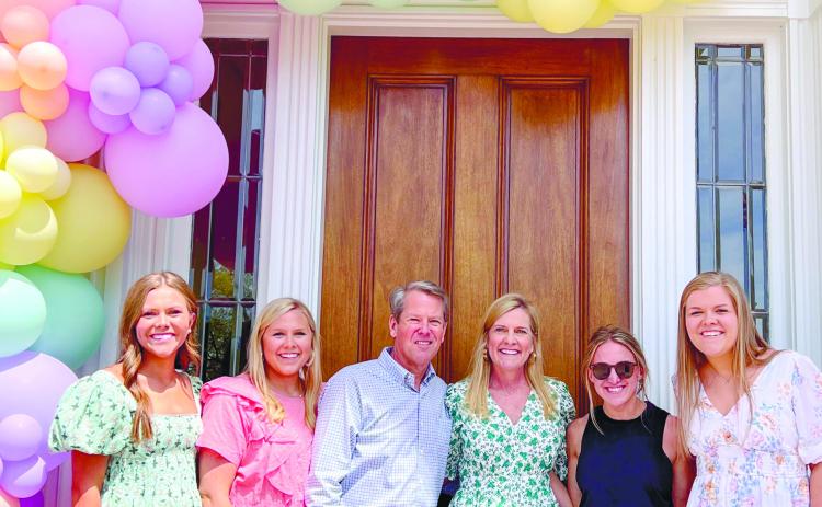 Anna Grace Pryor (wearing black) stands under the balloon arch that she designed with Gov. Brian Kemp’s family. CONTRIBUTED