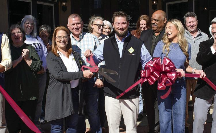 Front row, l-r: Phillip Joiner, VP of business development at 1-800 Water Damage of Central Georgia, company co-owners Anna (with scissors) and Jordan Demmon, co-owners Michelle and Gary Hogg, and Eatonton-Putnam Chamber of Commerce President Robbie King made the ribbon cut to officially mark the entry of Jordan Demmon to the Chamber. IAN TOCHER/Staff