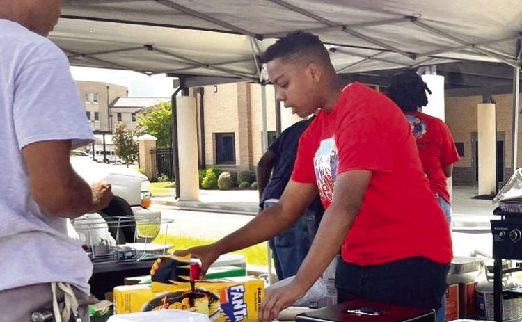 Temp Moore serves customers at the “Get In my Belly” food tent. ALIVIA BLANTON/Staff