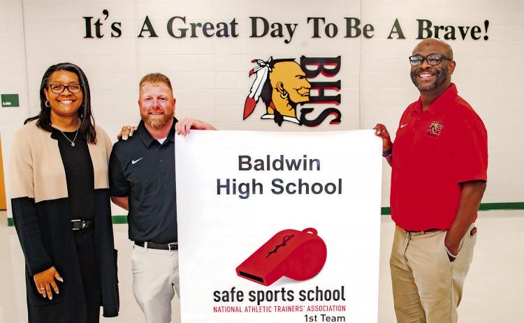 Andrew Shivers unveils Safe Sports School banner with BHS Principal Markeeta Clayton (left) and BCSD Athletic Trainer Dexter Ricks Sr. (right). CONTRIBUTED