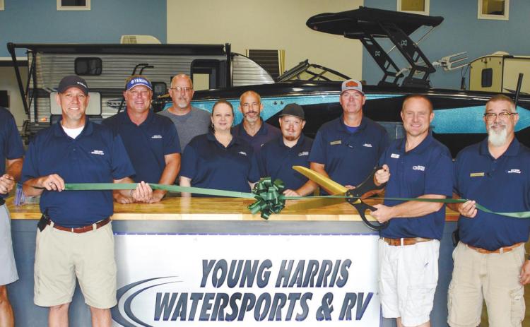Surrounded by employees new and old, Young Harris Watersports and RVs owner Lance Markham prepares to cut the ribbon. IAN TOCHER/Staff