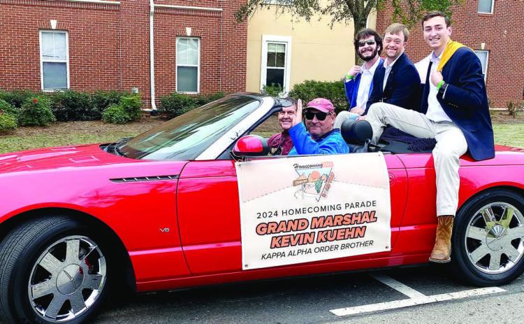 Chapter President Matt Rose (left) and brother Thomas Smith ride with Grand Marshal Kevin Kuehn (center) in the parade float. CONTRIBUTED/Matt Rose
